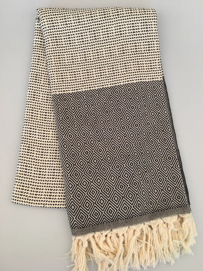 "Lycia Patara Turkish towel peshtemal in cream and gray with geometric patterns and fringed edges, laid flat"