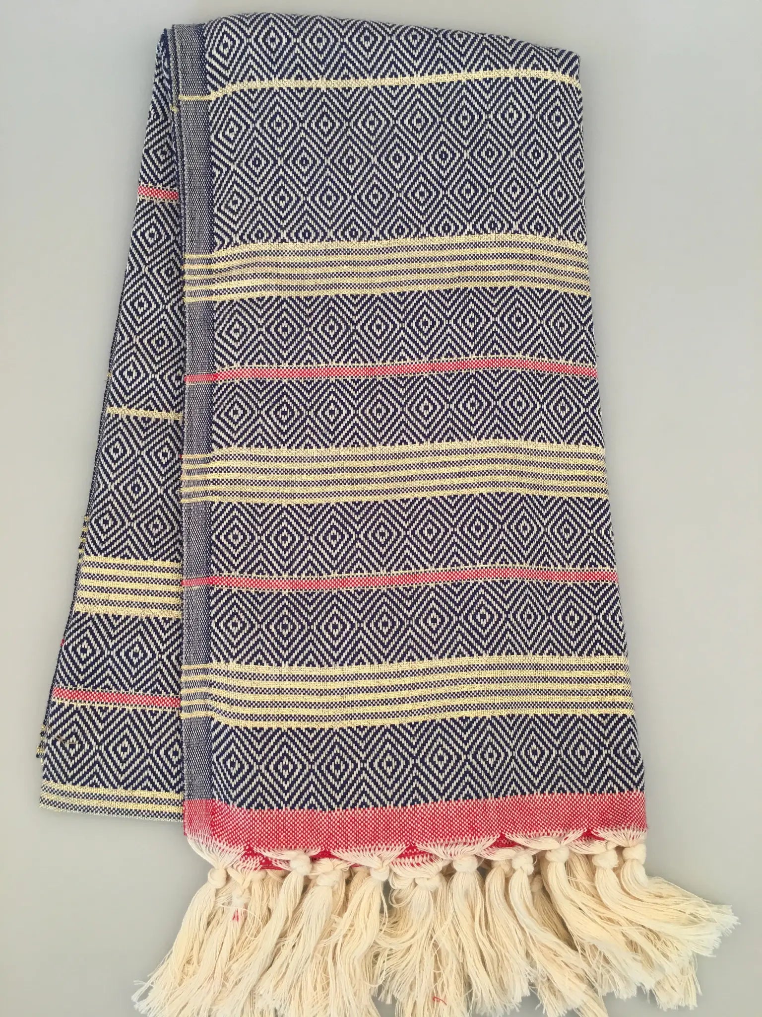 "Lycia Xanthos Turkish towel peshtemal in blue and white diamond pattern with red and cream stripes, fringed edges."