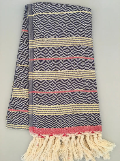 "Lycia Xanthos Turkish towel peshtemal in blue and white diamond pattern with red and cream stripes, fringed edges."