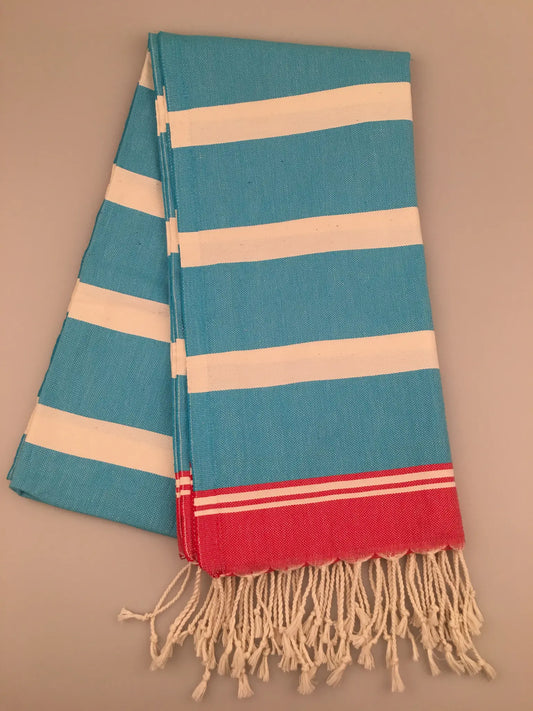 Turquoise and white striped Turkish towel with red accents and fringed edges, laid flat.